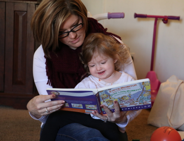 Kim with Scarlett, reading a book.