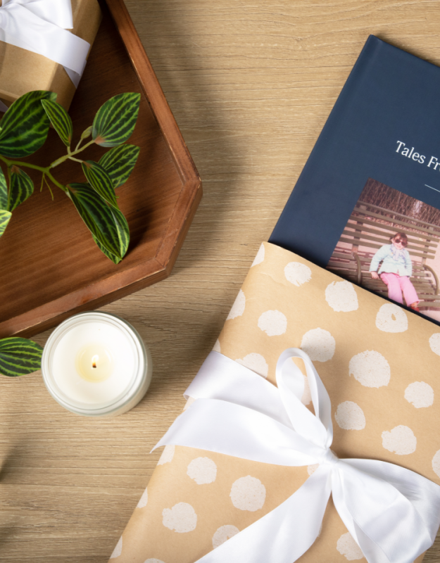 Remento gift book in a pretty package on a table with flowers and a candle